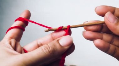 Kadın eli örgü örmek için kanca ve iplik kullanıyor.