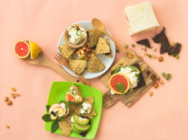 Dilimlenmiş portakal, avokado, krem peynirli elma, ev yapımı kanape meyvesi ve ekmek.