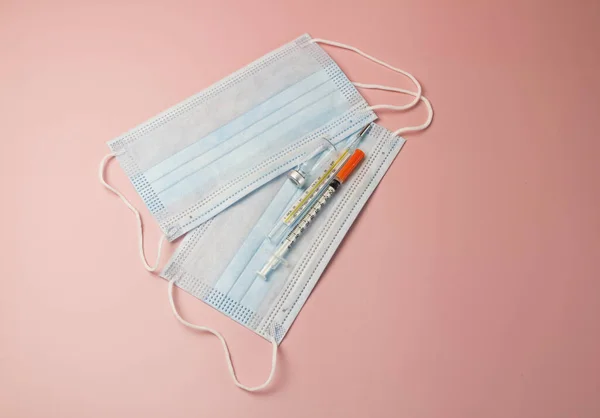Clinical Thermometer,Syringe,vaccine bottle and Mask put on pastel background