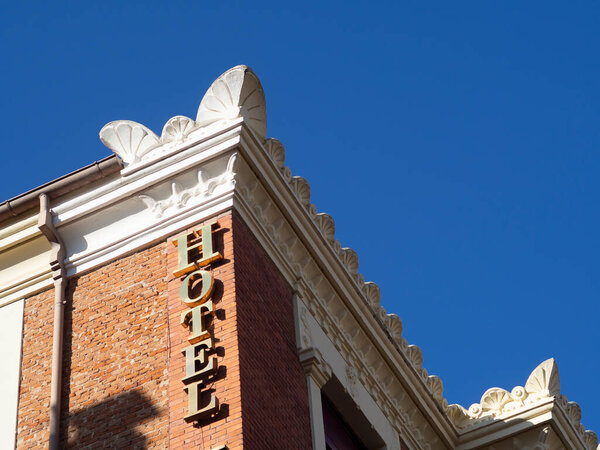 Historical Modernist hotel lettering with red brick wall