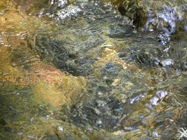 Kayaların arasından akan doğal bir pınarın ferahlatıcı suyu.