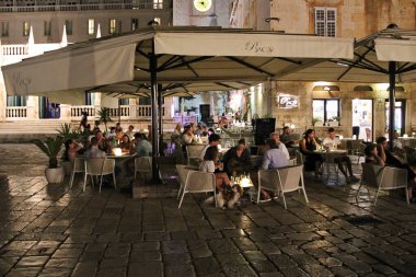 Hvar, Hırvatistan - 22 Ağustos 2025: Hırvatistan 'ın Hvar Adasındaki Hvar Eski Kasabasındaki Zarif Hırvat Bar Terasında Gece Oturanlar