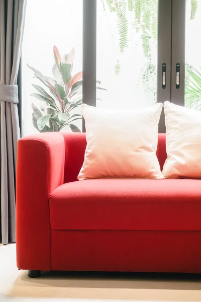 Sofá rojo con almohadas y lámpara de luz — Foto de Stock