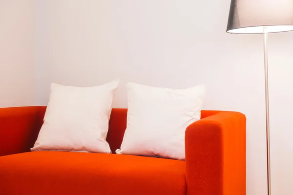 红色的沙发上，用枕头和灯 — 图库照片