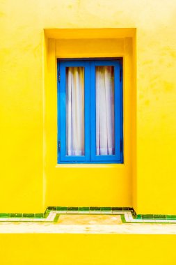 Sarı duvardaki mavi pencere
