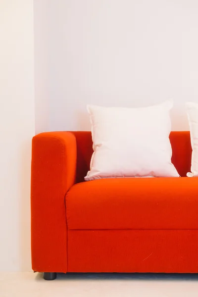 Sofá vermelho com travesseiros e luz lâmpada — Fotografia de Stock
