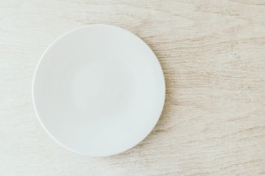 Beyaz ahşap zemin üzerinde beyaz tabak
