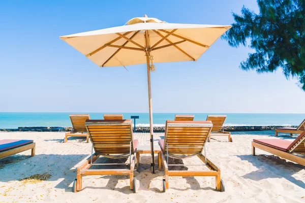 Sonnenschirm und Liegestuhl am Strand — Stockfoto