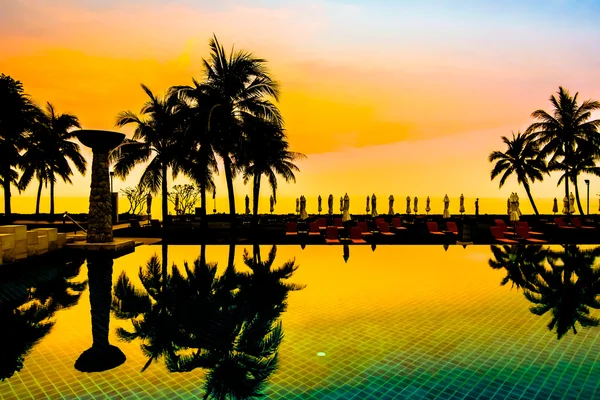 Silhouettes of palm trees on swimming pool