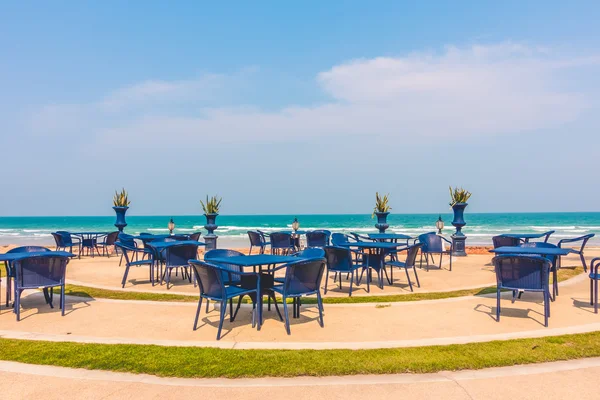 Boş masa ve sandalye plaj arka plan etrafında — Stok fotoğraf