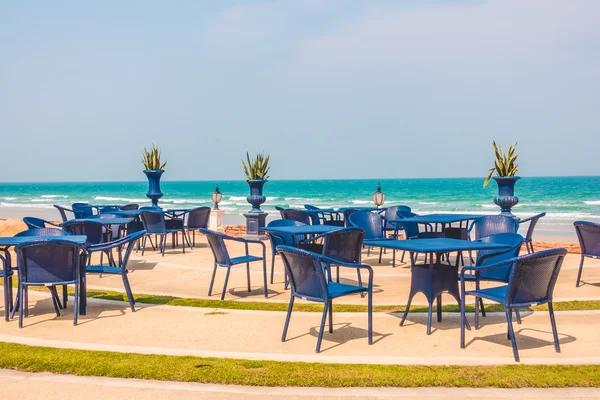 Lege tafel en stoel rond beach achtergrond — Stockfoto