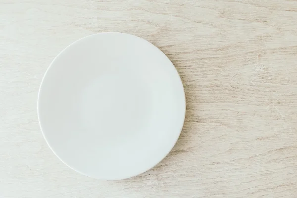 White plate on white wood background — Stock Photo, Image