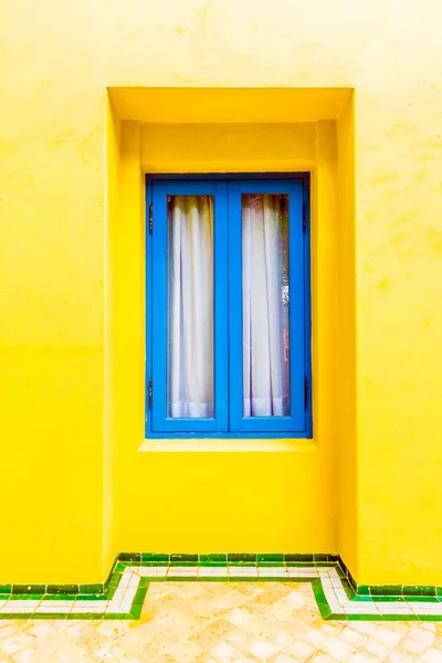 黄色墙上的蓝色窗户 — 图库照片
