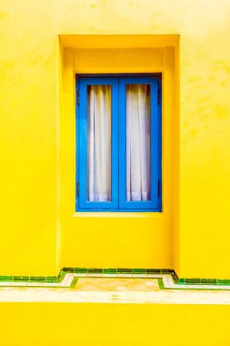 Sarı duvardaki mavi pencere