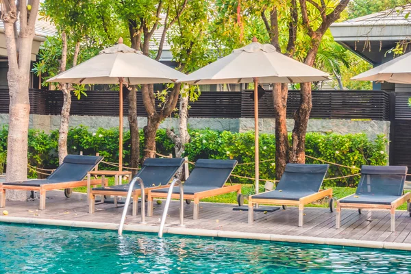 Umbrellas and chairs around swimming pool — Stock Photo, Image