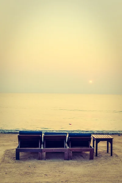 Cadeiras vazias na praia com horário de pôr do sol — Fotografia de Stock