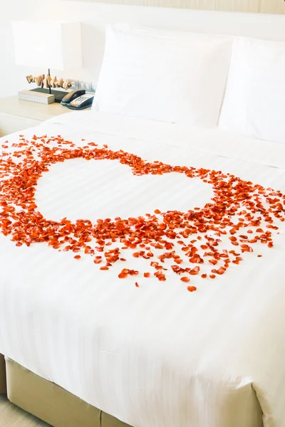 Almohadas blancas en la cama y pétalos de rosa — Foto de Stock