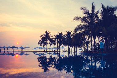 Ve Yüzme Havuzu palmiye ağaçlarının Silhouettes