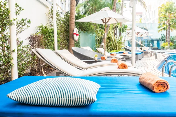 Guarda-chuva e cadeira em torno da bela piscina de luxo — Fotografia de Stock
