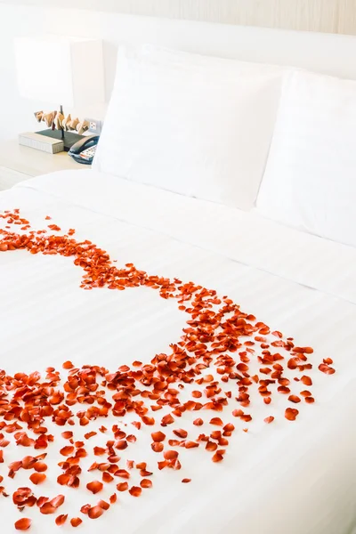 Almohadas blancas en la cama y pétalos de rosa — Foto de Stock