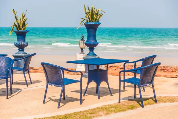 Mesa vazia e cadeira em torno do fundo da praia — Fotografia de Stock