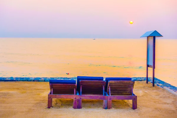 Cadeiras vazias na praia com horário de pôr do sol — Fotografia de Stock