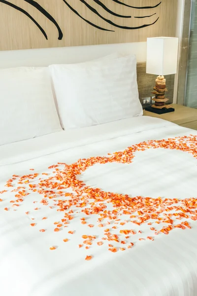 Almohadas blancas en la cama y pétalos de rosa — Foto de Stock