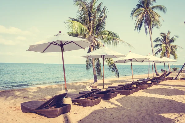 Sonnenschirme und Liegestühle am tropischen Strand — Stockfoto