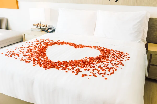 Cuscini bianchi sul letto e petali di rosa — Foto Stock