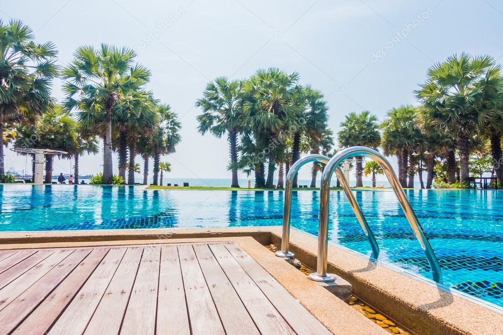 Swimming pool with palm trees and sea