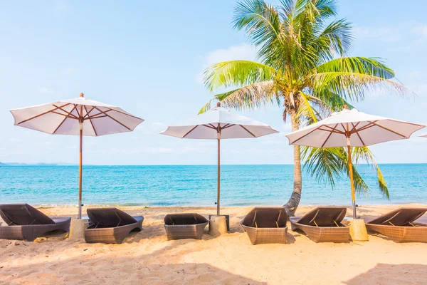Şemsiyeleri ve sandalyeler tropik sahilde