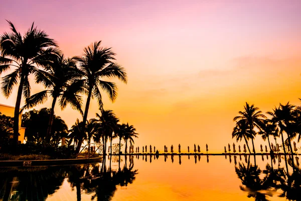 Silhouettes of palm trees on swimming pool