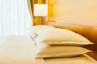 Yatakta ışık lamba ile beyaz yastıklar