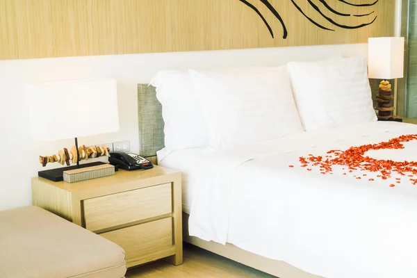 Cuscini bianchi sul letto e petali di rosa — Foto Stock