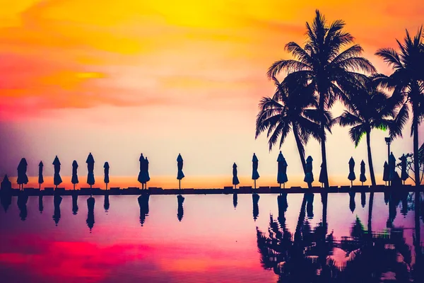 Silhouettes of palm trees on swimming pool