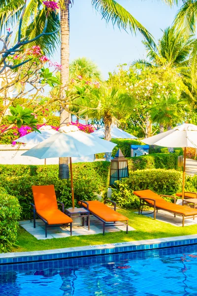 Umbrellas and chairs around swimming pool — Stock Photo, Image