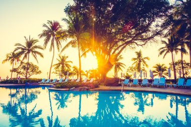 açık şemsiye ve havuz etrafında sandalyeler