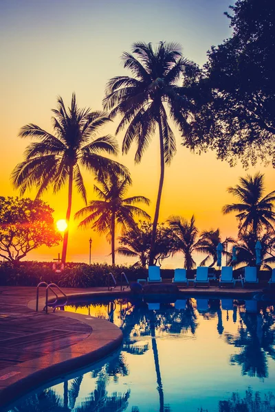 Outdoor umbrellas and chairs around pool — Stock Photo, Image