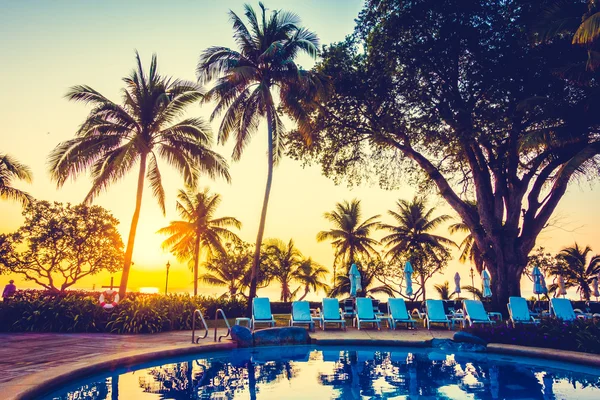 açık şemsiye ve havuz etrafında sandalyeler