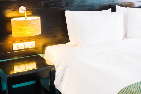 침대와 벽에 조명 램프에 베개 — 스톡 사진