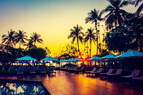 Silhouettes of coconut palm trees with umbrellas — Stock Photo, Image