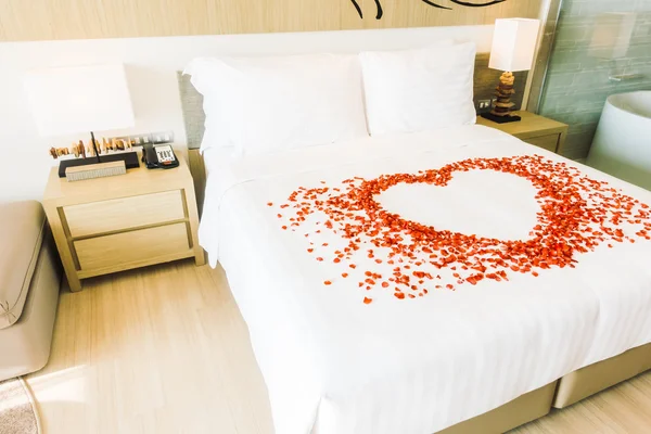 Белые подушки на кровати и лепестки роз — стоковое фото