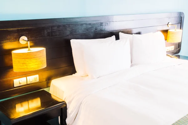 Almohadas blancas en la cama y lámpara de luz — Foto de Stock