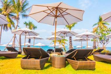 Şemsiyeleri ve sandalyeler tropik sahilde