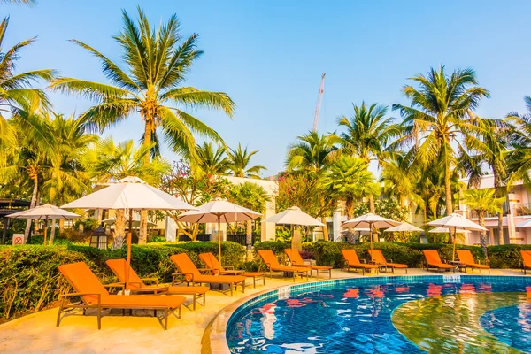 Umbrellas and chairs around swimming pool — Stock Photo, Image