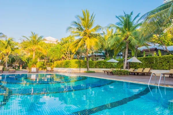 Swimming pool with palm trees and sea — Stock Photo, Image