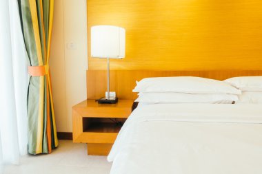 Yatakta ışık lamba ile beyaz yastıklar