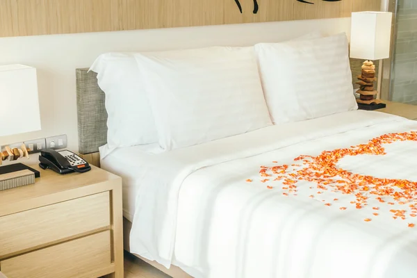Almohadas blancas en la cama y pétalos de rosa — Foto de Stock