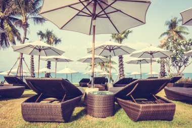 Şemsiyeleri ve sandalyeler tropik sahilde