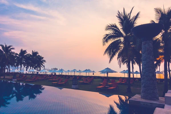 Silhouettes of palm trees on swimming pool